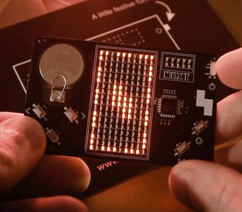 A close-up photo of the LED matrix screen on an interactive business card
